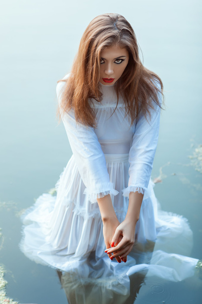 Красива дівчина стоїть у водяній сукні
. - Фото, зображення