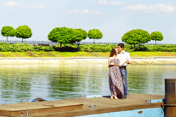 Young man and woman standing together on pier - 写真・画像