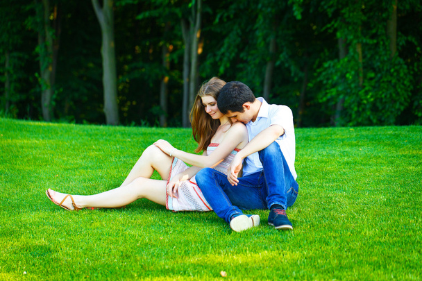 Aşık adam ve çim üzerinde oturan kadın - Fotoğraf, Görsel