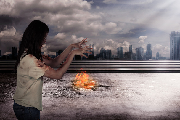 Şehir arka plan yanma ile korkunç kadın zombi - Fotoğraf, Görsel