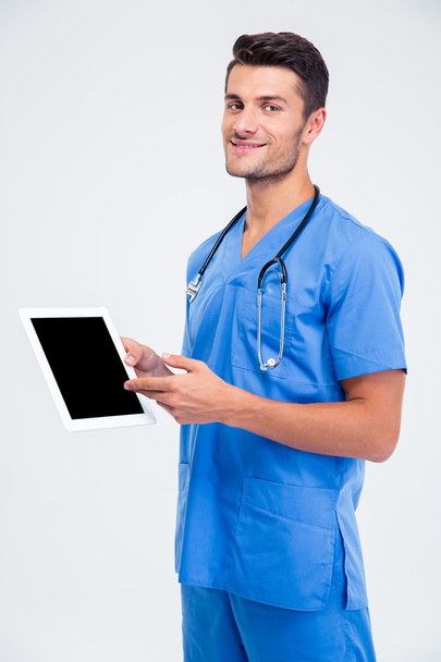 Male doctor showing finger on tablet computer screen - 写真・画像