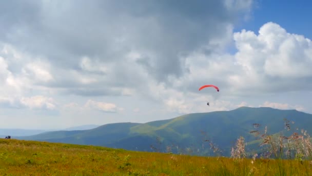 paraglidista létající v horách - Záběry, video