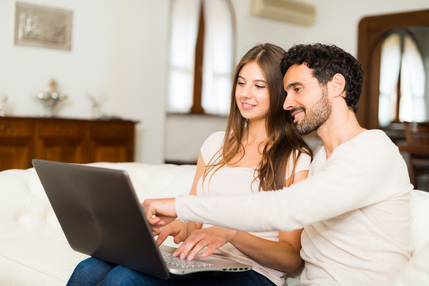 pareja usando ordenador portátil en casa
 - Foto, Imagen