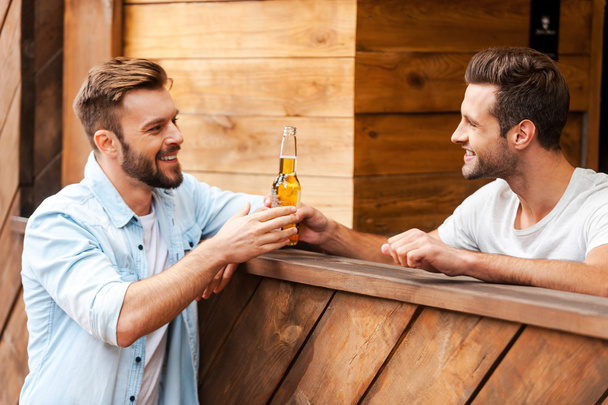bartender giving a bottle of beer to his client - Fotoğraf, Görsel
