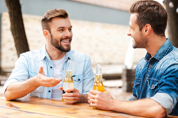 men talking and holding bottles with beer - Fotoğraf, Görsel