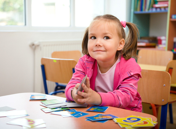 Cute little girl is playing with educational cards - Photo, Image