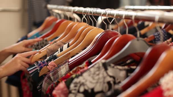 glückliches Mädchen wählt neues Kleidungsstück im Modegeschäft - Filmmaterial, Video