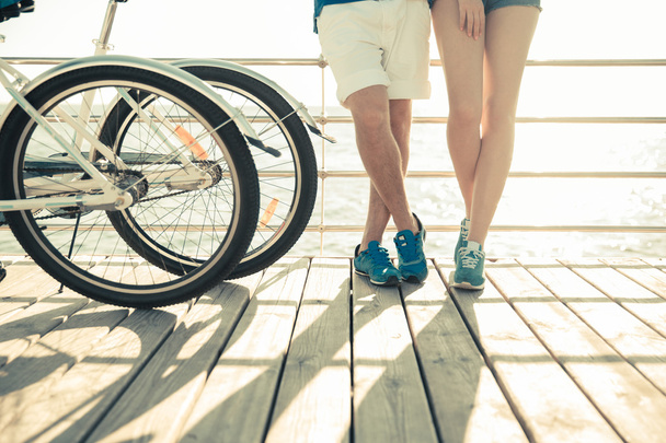 Mannelijke en vrouwelijke benen met fiets buitenshuis - Foto, afbeelding