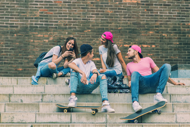 Skateboarders sentados nas escadas
 - Foto, Imagem