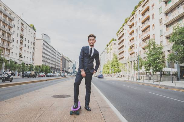 Young handsome Asian model posing with his skateboard - Fotoğraf, Görsel