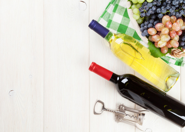fehér és vörös palack bort és a szőlő - Fotó, kép