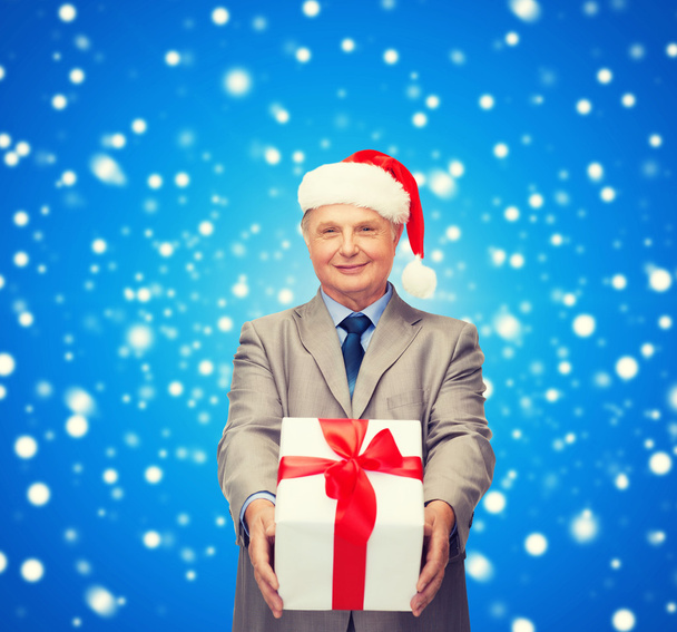 smiling man in santa hat with gift - Zdjęcie, obraz