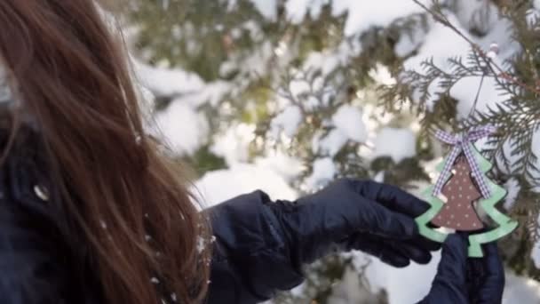 beautiful Christmas woman decorates a fur-tree in winter wood - Footage, Video