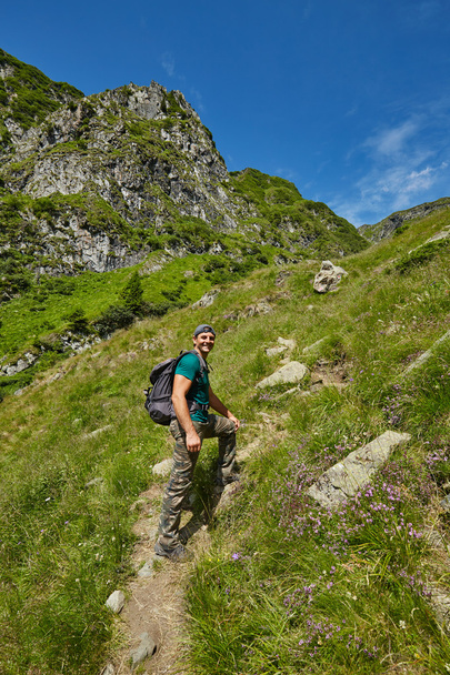 Happy hiker going up to the mountain peak - Zdjęcie, obraz