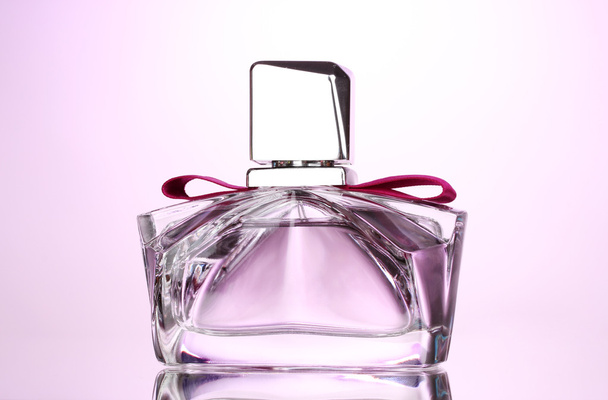 Women's perfume in beautiful bottle on pink background - 写真・画像