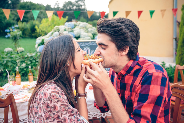 Funny young couple eating an american hot dog - Photo, Image