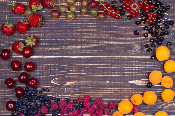 Strawberry, blueberry, blackberry, raspberry, cherry, apricots, gooseberry and currant, view from above, studio shot. - Fotografie, Obrázek