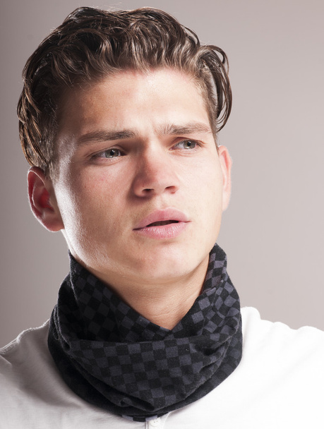 Handsome young man with curly hairstyle wearing scarf - Fotó, kép