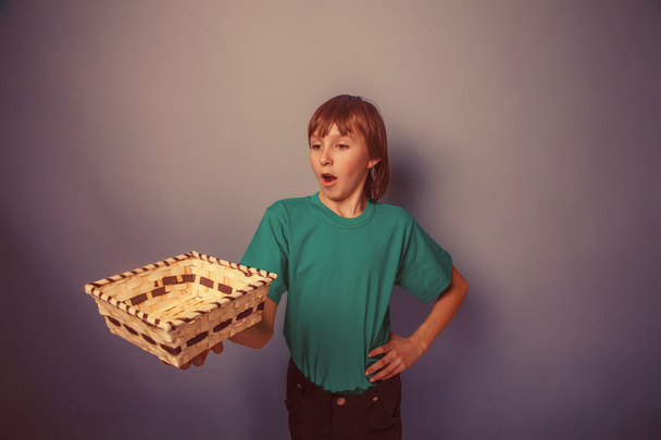 Ευρωπαϊκή εμφάνιση αγόρι δέκα ετών κρατώντας ένα άδειο καλάθι στη - Φωτογραφία, εικόνα