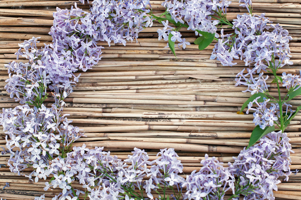 Corona de lila sobre fondo de caña seca
 - Foto, Imagen
