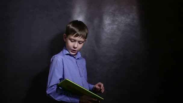 Tizenéves fiú futás-ra tabletta világoskék inget stúdió háttér videó - Felvétel, videó