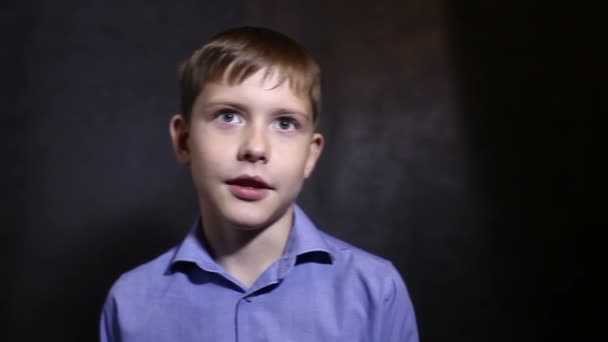 10 代の少年は言うビデオ スタジオの背景を笑顔青いシャツを着てインタビューを話の話 - 映像、動画