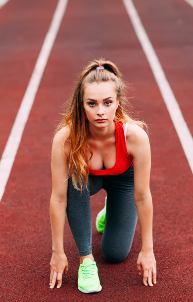 Athletic woman on track starting to run. Healthy fitness concept - Foto, Imagen