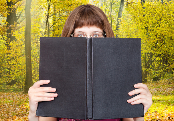 Kız rooks büyük kitap ve güneşli orman - Fotoğraf, Görsel