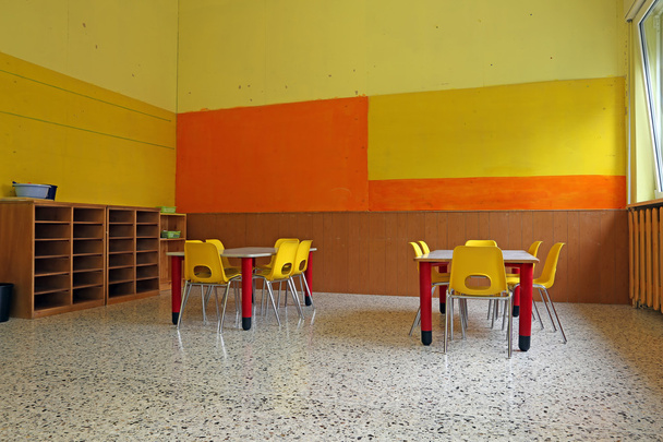 lastentarhan luokkahuone, jossa työpöydät ja keltaiset tuolit
 - Valokuva, kuva