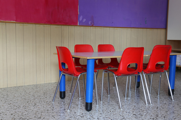 sala de aula de jardim de infância com mesas e cadeiras vermelhas
 - Foto, Imagem