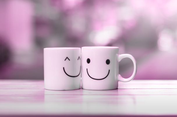 Две чашки счастья на деревянном столе с боке, о концепции любви
 - Фото, изображение