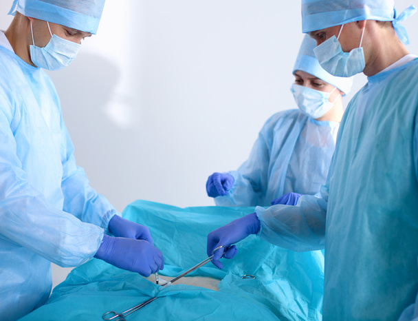 Il team di chirurgo in uniforme esegue un'operazione su un paziente presso la clinica di chirurgia cardiaca
 - Foto, immagini