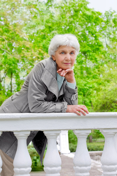 linda anciana senior en la hermosa veranda blanca en el parque
 - Foto, imagen