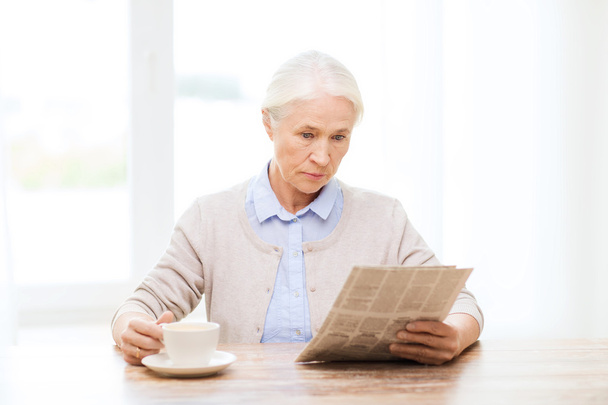 senior woman with coffee reading newspaper - Φωτογραφία, εικόνα