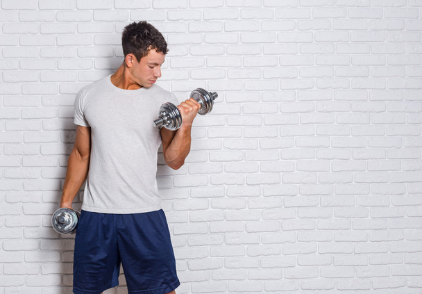 Portrait of a muscular man lifting weights - Fotoğraf, Görsel