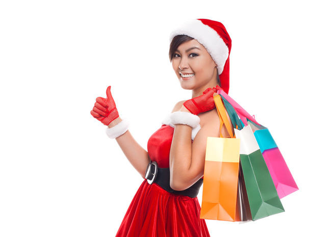Christmas shopping woman thinking wearing santa hat and holding - 写真・画像