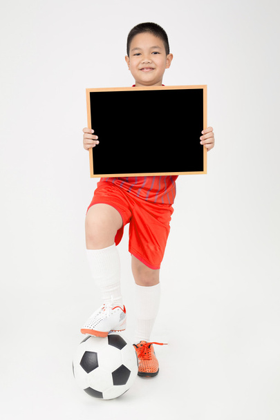 Маленький азіатський хлопчик тримає порожню дерев'яну дошку в спортивній формі
 - Фото, зображення