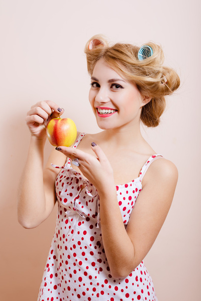 lady in curlers holding big red apple - Fotografie, Obrázek