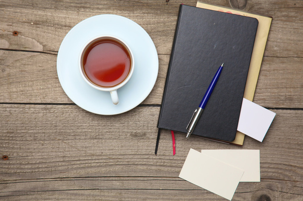 Puste karty biznesowe z długopis, notatnik i herbaty kubek na stole drewniane biura - Zdjęcie, obraz
