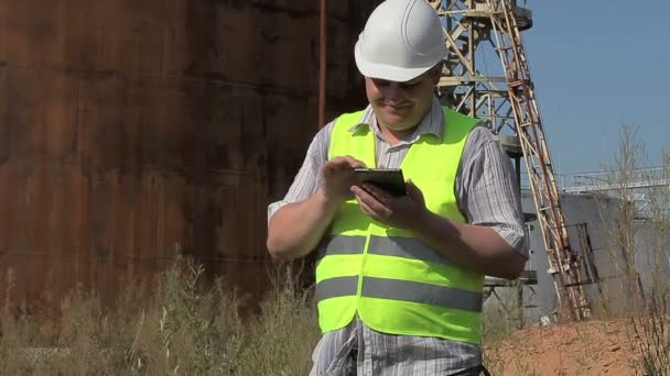 Šťastný inženýr používající Tablet PC blízko nádrží - Záběry, video