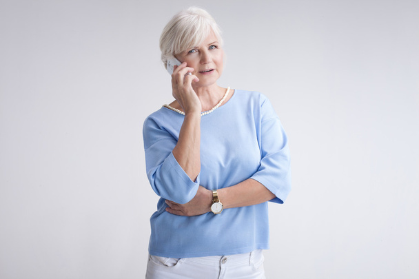 Portrait of attractive senior woman with mobile phone. - 写真・画像