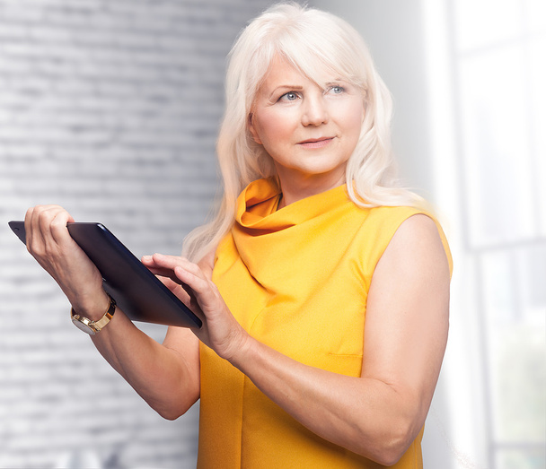 Portrait of attractive senior businesswoman using tablet. - Foto, immagini