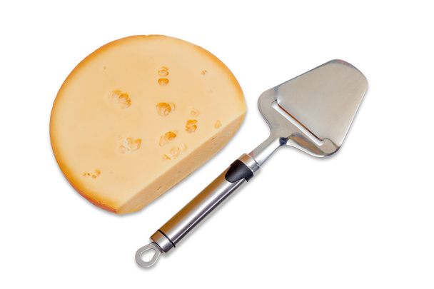 Stück Käse und Käsehobel auf hellem Hintergrund - Foto, Bild
