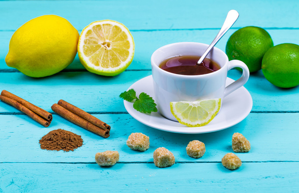 Tea with a lemon, a lime, cinnamon, a melissa and cane sugar - Фото, изображение
