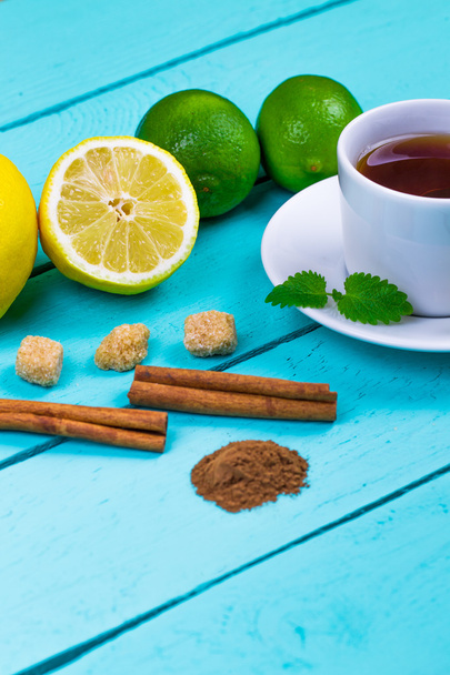 Tea with a lemon, a lime, cinnamon, a melissa and cane sugar - Zdjęcie, obraz