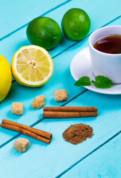 Tea with a lemon, a lime, cinnamon, a melissa and cane sugar - Zdjęcie, obraz