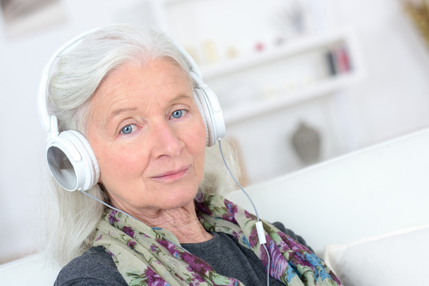 Old lady with headphones on - Фото, изображение