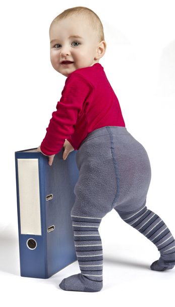 Pieni lapsi seisoo sinisen rengaskansion vieressä
 - Valokuva, kuva