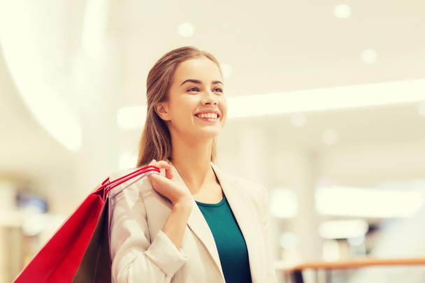 happy young woman with shopping bags in mall - Фото, зображення
