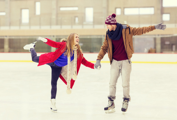 happy couple holding hands on skating rink - Photo, image